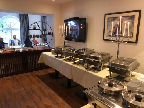 a restaurant with a buffet line with pots and pans at WH Hotels Papenburg Zentrum in Papenburg