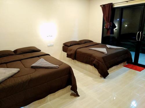 a room with two beds and a window at เฟรนด์แคมป์ in Khao Kho