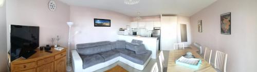 uma sala de estar com um sofá no meio de uma cozinha em Appartement T3 - 4 personnes - Face Océan - Thalasso em Pornichet