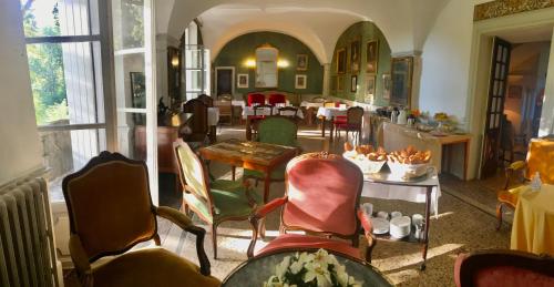 een kamer met stoelen en een tafel en een eetkamer bij Hôtel Château Du Rey in Saint-André-de-Majencoules