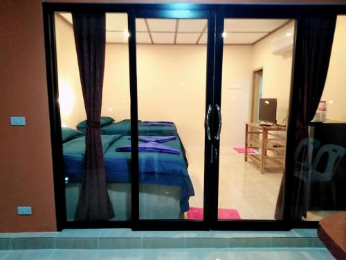 a bedroom with a bed through a glass door at เฟรนด์แคมป์ in Khao Kho