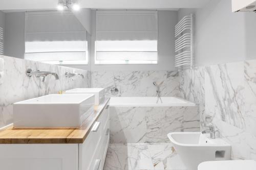 biała łazienka z 2 umywalkami i toaletą w obiekcie Rezydencja Lipowa 18A w mieście Gdynia