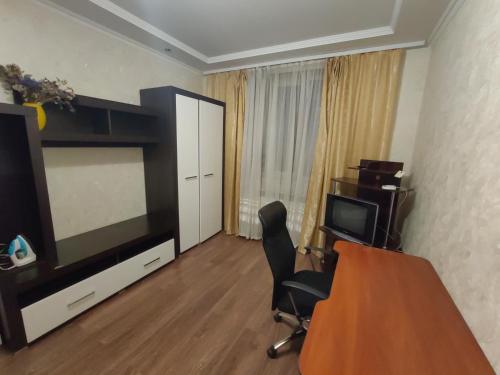 a living room with a television and a table and a chair at Daily rent Apartments 5 in Ivano-Frankivsʼk