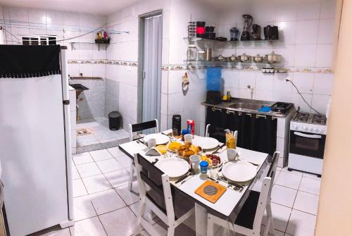 una cocina con mesa con sillas y mesa y una cocina con en Apartamento Vila Isabel, en Maragogi