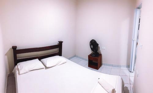 1 dormitorio con 1 cama y teléfono en Apartamento Vila Isabel, en Maragogi