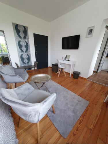 a living room with a couch and chairs and a table at Apartamenty pod Wieżą in Zgorzelec