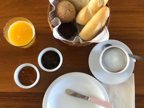 a table with a plate and cups of coffee and a basket of bread at Lagos del Furioso in Río Chico