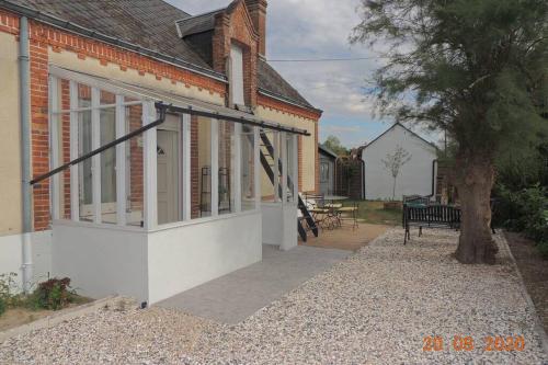 a house with a screened in porch with a bench at Gite le Bercail in Mur-de-Sologne
