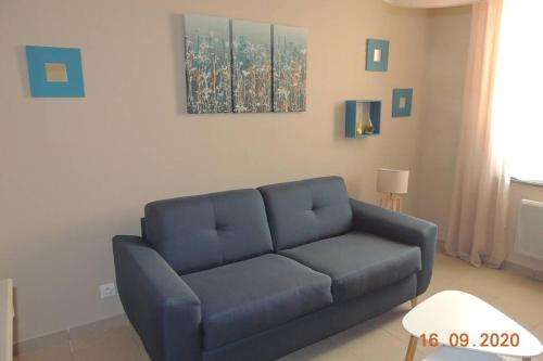 a blue couch sitting in a living room at Gite le Bercail in Mur-de-Sologne