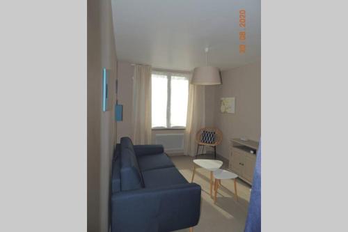 a living room with a blue couch and a table at Gite le Bercail in Mur-de-Sologne