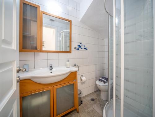 a bathroom with a sink and a toilet and a mirror at Avlaki Beachfront Villa in Kassiopi