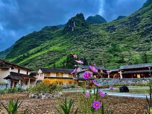 una montaña con flores frente a un edificio en O'Chau Meo Vac Homestay Ha Giang, en Mèo Vạc