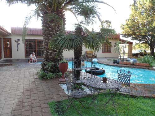 a patio with a table and chairs next to a pool at A Cherry Lane Self Catering and B&B in Bloemfontein