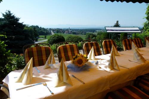 a table with a yellow table cloth and a sunflower on it at Landgasthof Entenwirt Tarsdorf in Tarsdorf
