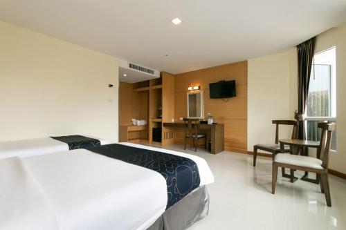 a hotel room with a bed and a desk and a television at Golden Beach Boutique Resort in Prachuap Khiri Khan