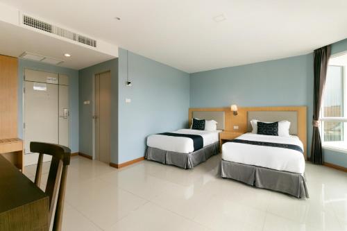 two beds in a room with blue walls at Golden Beach Boutique Resort in Prachuap Khiri Khan