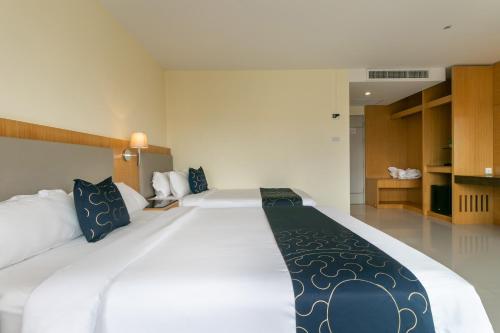 a large white bed in a hotel room at Golden Beach Boutique Resort in Prachuap Khiri Khan