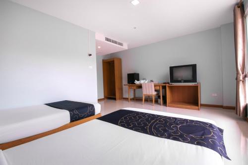 a hotel room with a bed and a tv at Golden Beach Boutique Resort in Prachuap Khiri Khan