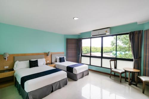 a hotel room with two beds and a window at Golden Beach Boutique Resort in Prachuap Khiri Khan