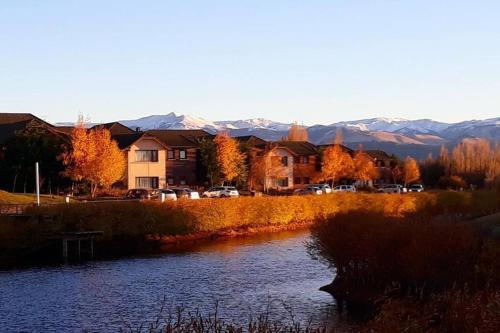 ディナ・ウアピにあるexcelente departamento 4 personas villa Dina huapi 2 ambientes amplios PBの川と家と山のある町