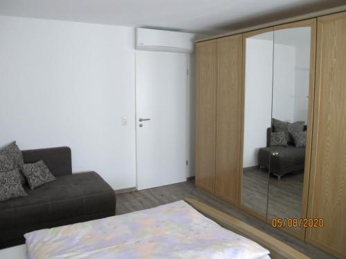 a living room with a couch and a mirror at Gästezimmer 1 mit Bad in Angersbach