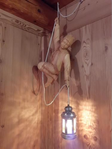 a statue of a man hanging on a wall with a light at tana del paradiso due in Baceno