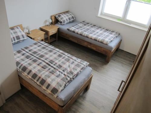 two beds in a room with two windows at Ruhiges Zimmer 2 in Angersbach