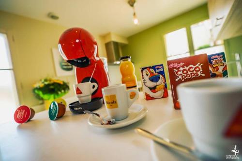a counter top with a coffee cup and figurines on it at Maison PISCINE INTERIEURE et GARAGE in Troyes