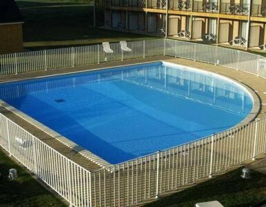 une grande piscine bleue dans un immeuble dans l'établissement FORMISTUDIO II, à Équemauville