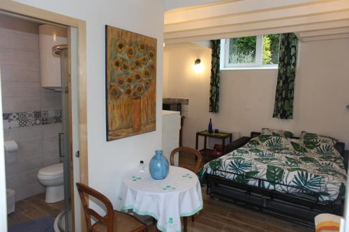 a bedroom with a table and a bed and a bathroom at studio près du Mont Saint Michel in Champeaux