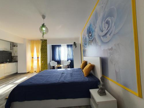 um quarto com uma cama azul e uma cozinha em Garsoniera Argedava em Bucareste