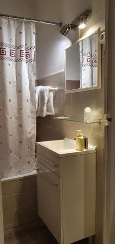 a bathroom with a shower curtain and a sink at Will's Hotel in Narbonne