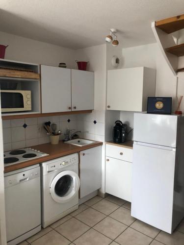 une cuisine avec des armoires blanches et une machine à laver dans l'établissement LES MARINES 1 9217, à Dives-sur-Mer