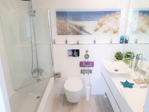 a bathroom with a toilet and a shower and a sink at Avenida dos Banhos Apartment in Póvoa de Varzim