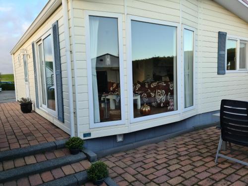 a house with large windows on the side of it at Strandhut 64 in Sint Annaland