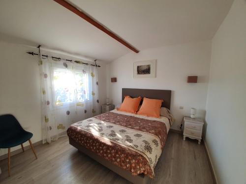 a bedroom with a bed with orange pillows and a window at Villa Dora in Frontignan