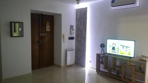 a living room with a door and a tv on a table at Stella Marina - voglia di vacanza e di relax in Genova