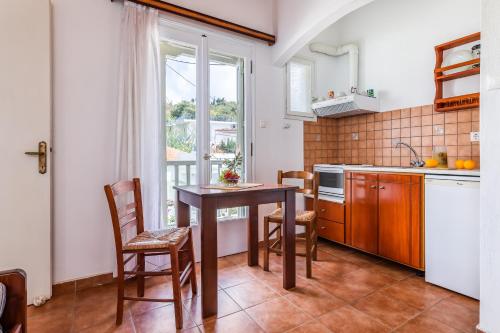 a kitchen with a table and chairs and a window at Servani Studios & Suites in Loutraki