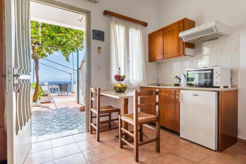 a kitchen with a counter with chairs and a microwave at Servani Studios & Suites in Loutraki