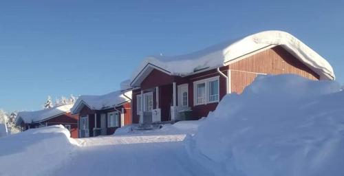 a pile of snow in front of a house at Lomamaja Pekonen Apartments in Muonio
