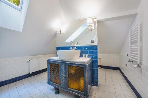 baño con lavabo y azulejos azules y blancos en Apartamenty Kurort, en Kołobrzeg