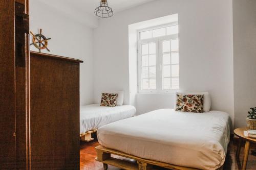 a bedroom with two beds and a window at Jaca Hostel Porto da Cruz in Porto da Cruz