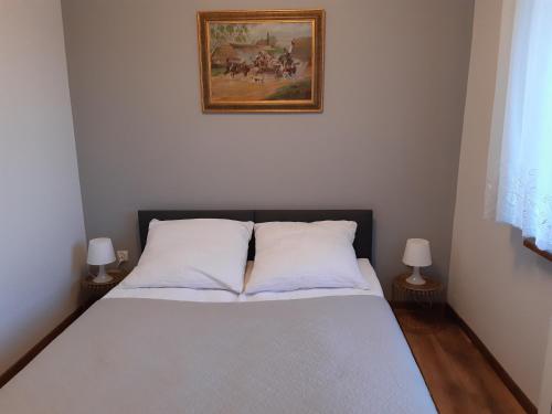 a bed with two pillows and a picture on the wall at SECESJA HOUSE in Oświęcim