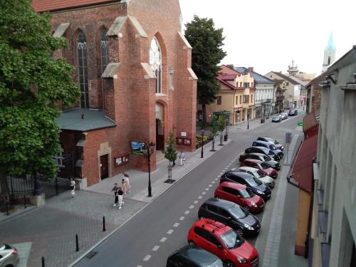 a row of cars parked on a street next to a building at SECESJA HOUSE in Oświęcim