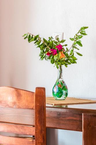 a vase with flowers in it sitting on a table at Servani Studios & Suites in Loutraki