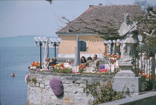 a statue of a woman sitting at a table near the water at Ferienwohnung Heidi Batzlen in Daisendorf