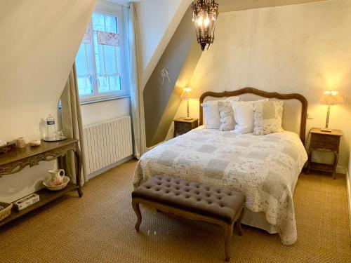 a bedroom with a bed and a bench in it at L'ange est rêveur in Langeais