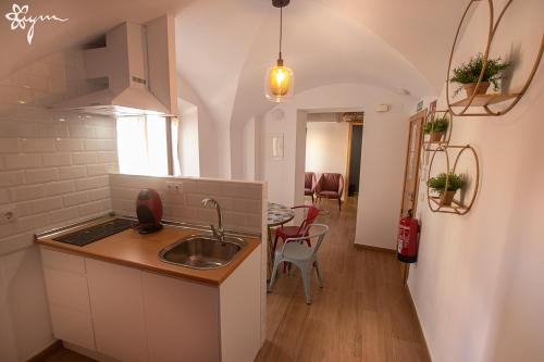 a small kitchen with a sink and a table at Apartamentos Turísticos AbrilyMarzo in Cáceres