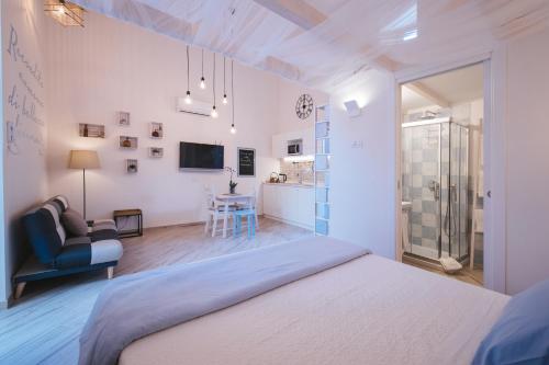 una camera bianca con letto e soggiorno di Recondita Armonia a Sorrento