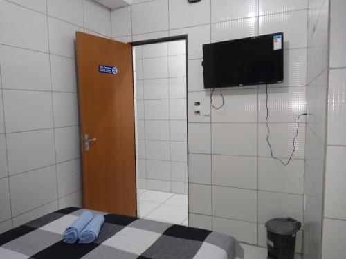 a bathroom with a door with a tv on the wall at HOTEL CIDADE EXPRESS 24H in Teresina